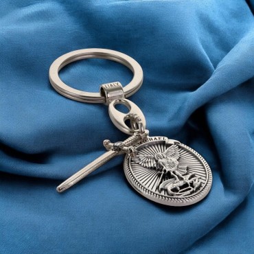 Porte cles en metal forme ovale avec St Michel entouré de rayons accompagné d'une épée en breloque H 3 cm