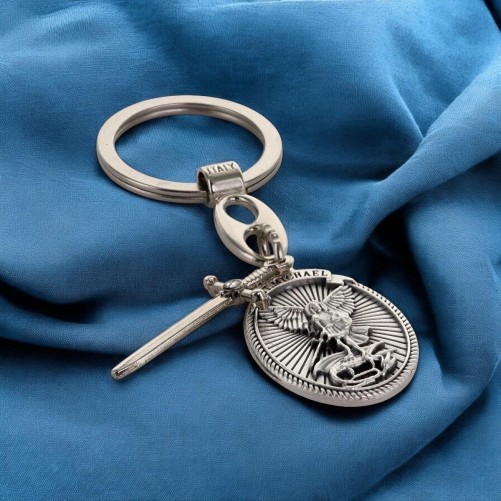 Porte cles en metal forme ovale avec St Michel entouré de rayons accompagné d'une épée en breloque H 3 cm