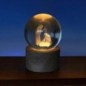 Boule sur socle en bois avec nativité gravée au laser et lumière LED. Hauteur 9 cm..