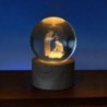 Boule sur socle en bois avec nativité gravée au laser et lumière LED. Hauteur 9 cm..