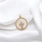 Médaille en coquille et laiton de couleur dorée avec croix en zircon, Ø 1.5 cm.