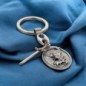 Porte cles en metal forme ovale avec St Michel entouré de rayons accompagné d'une épée en breloque H 3 cm