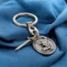 Porte cles en metal forme ovale avec St Michel entouré de rayons accompagné d'une épée en breloque H 3 cm