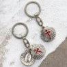 Porte-cles ouvrant de saint Jacques forme coquille Ø 3 cm avec 2 resines saint Jacques et saint Christophe.