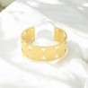 Bracelet manchette de Saint Benoit en acier inoxydable de couleur dorée, ajustable au poignet. Ø intérieur 6.3 cm.
