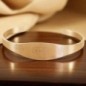 Bracelet jonc réglable en acier inoxydable couleur doré, médaille de Saint Benoît gravée.