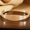 Bracelet jonc réglable en acier inoxydable couleur doré, médaille de Saint Benoît gravée.