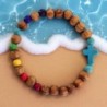 Bracelet élastique, perles en bois Ø 7 mm, croix en turquoise synthétique. Lot de 4 assortis.