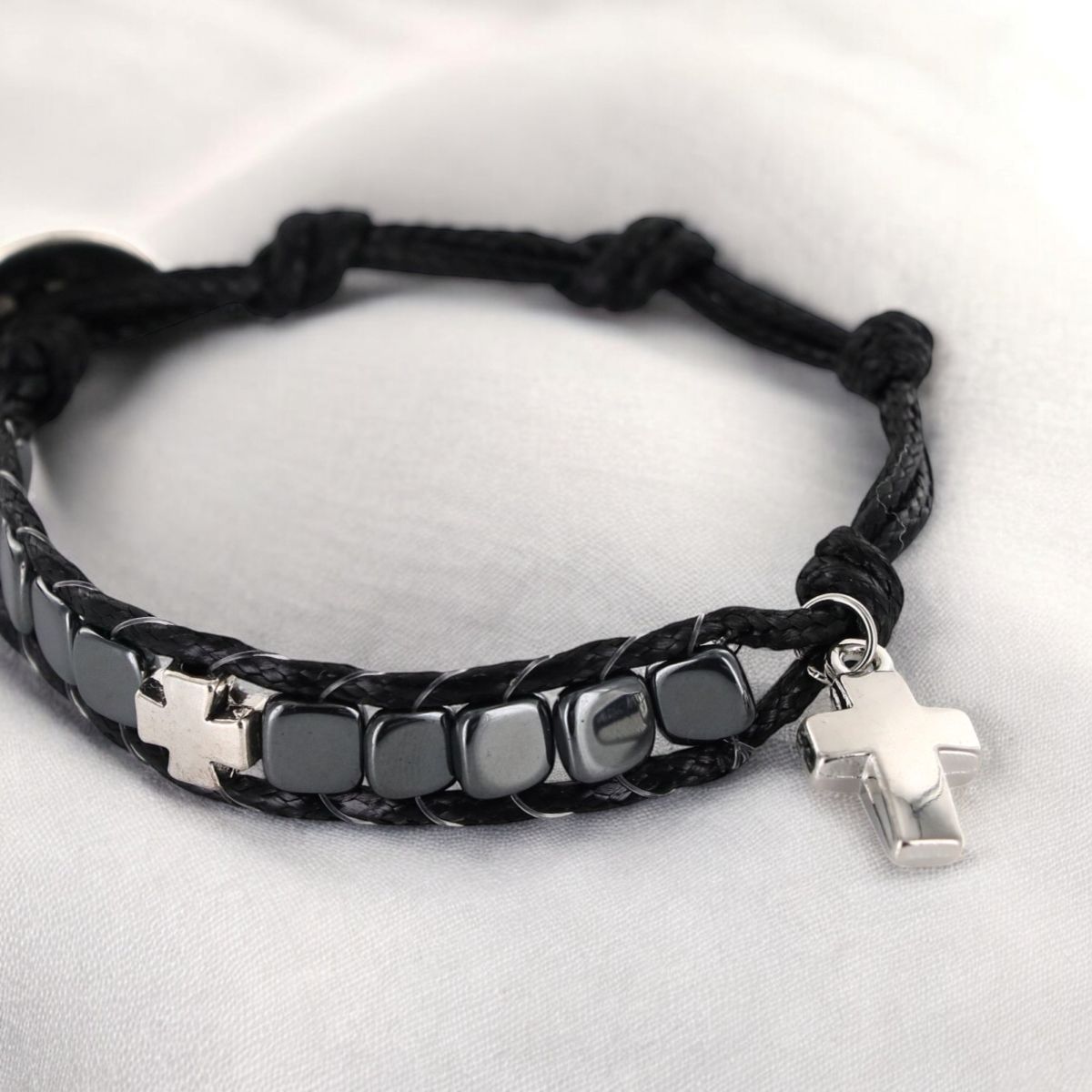 Bracelet dizainier ajustable sur corde de couleur noire avec grains carrés en hématite et croix en métal.