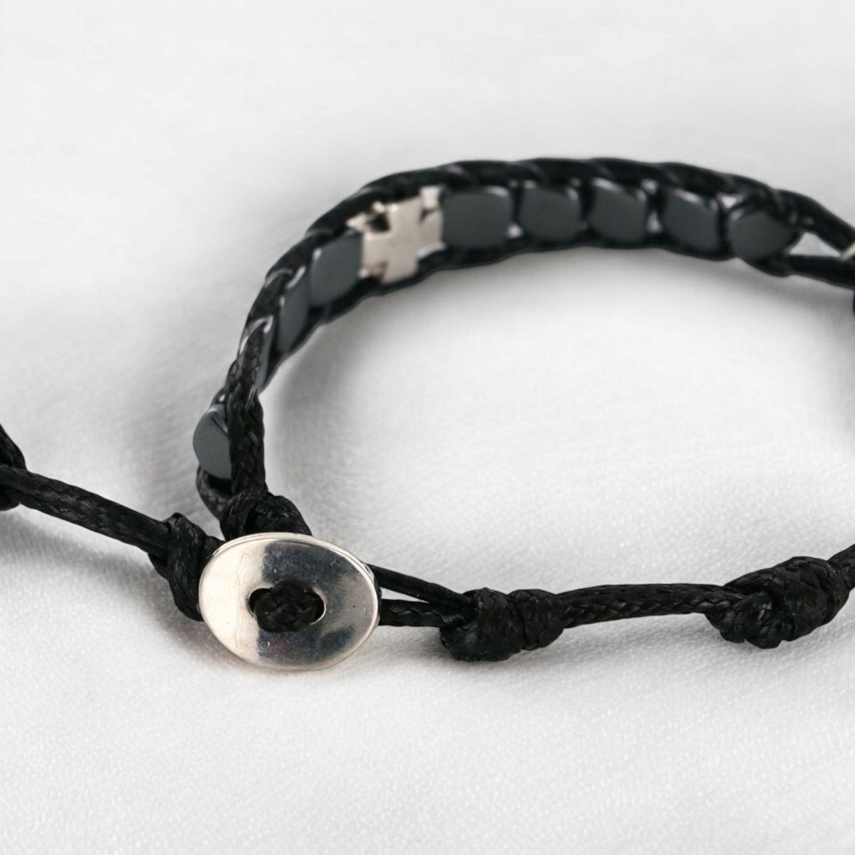 Bracelet dizainier ajustable sur corde de couleur noire avec grains carrés en hématite et croix en métal.